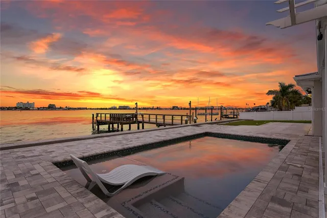 a view of swimming pool with outdoor seating and lake view