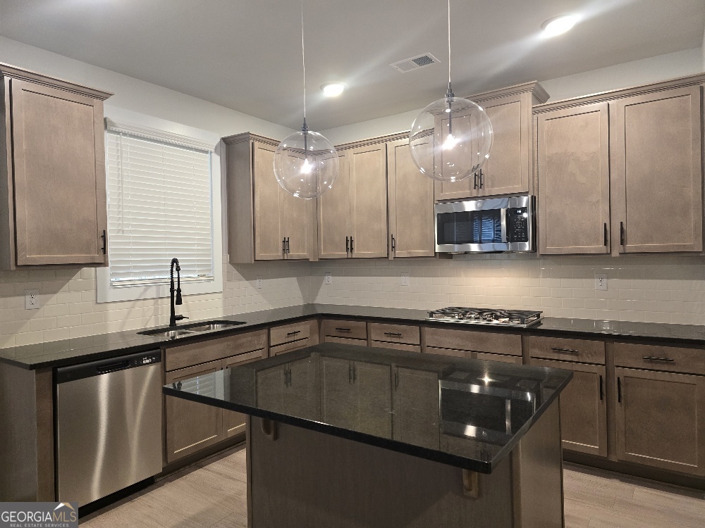 128 Patillo Manor, Unit 7 Stockbridge, GA 30281 - Photo 11 of 37 a kitchen with a sink stove and microwave