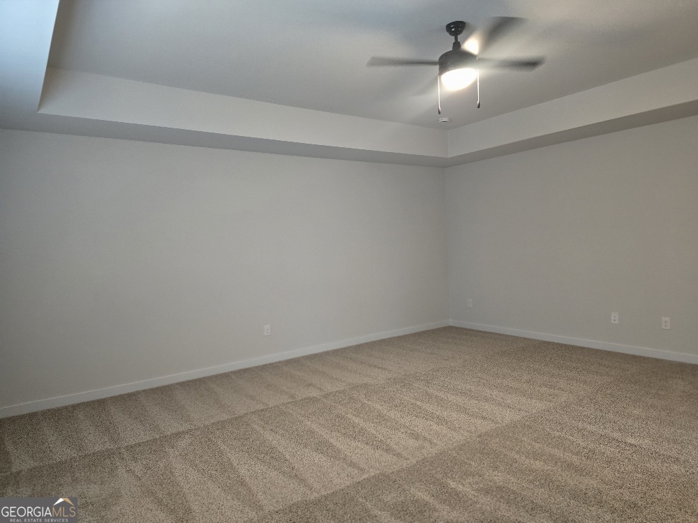 128 Patillo Manor, Unit 7 Stockbridge, GA 30281 - Photo 30 of 37 an empty room with a empty space and a ceiling fan