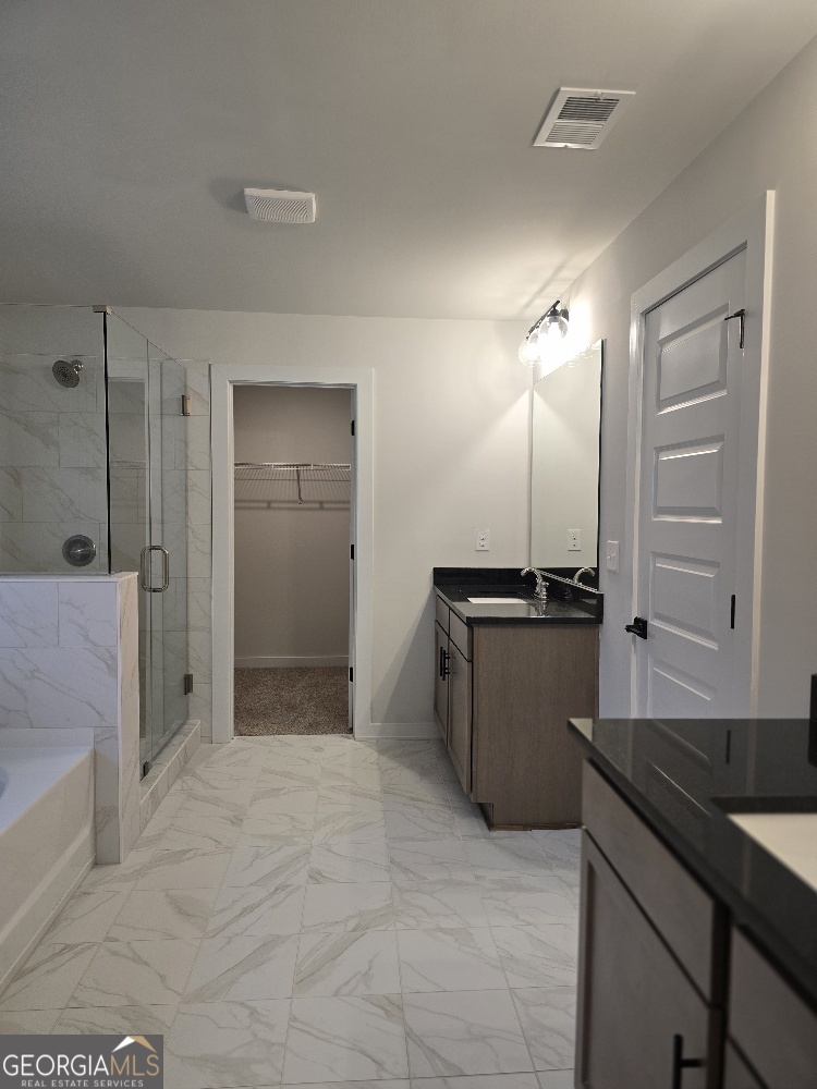 128 Patillo Manor, Unit 7 Stockbridge, GA 30281 - Photo 32 of 37 a large bathroom with a granite countertop sink a large mirror and a shower