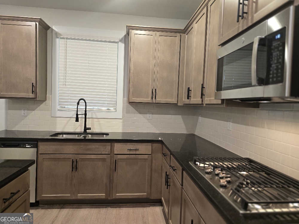 128 Patillo Manor, Unit 7 Stockbridge, GA 30281 - Photo 6 of 37 a kitchen with sink a microwave and cabinets