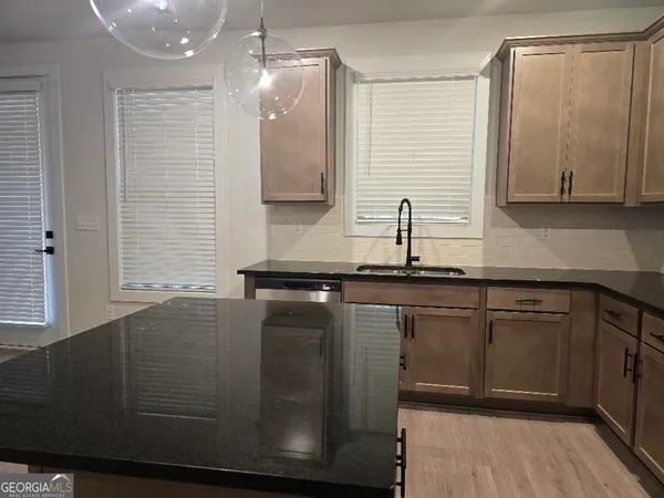 a large kitchen with stainless steel appliances kitchen island granite countertop a refrigerator and a stove top oven
