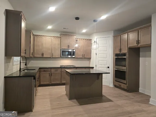 a large kitchen with granite countertop a sink and cabinets