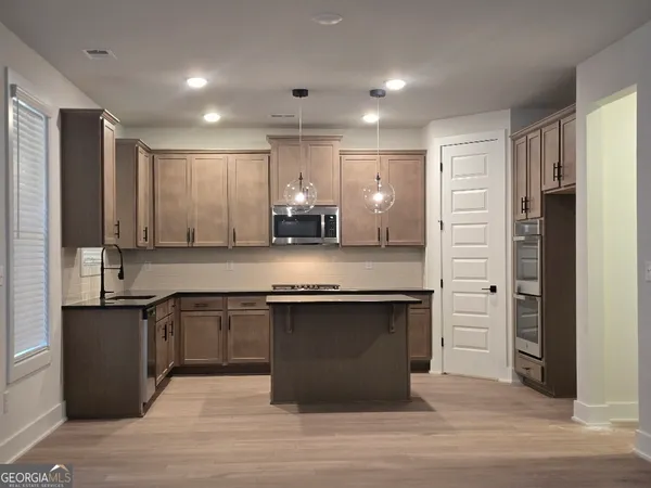 a kitchen with granite countertop white cabinets stainless steel appliances and sink