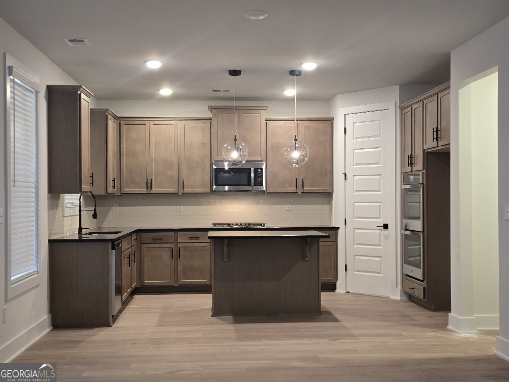 128 Patillo Manor, Unit 7 Stockbridge, GA 30281 - Photo 9 of 37 a large kitchen with granite countertop a sink and cabinets