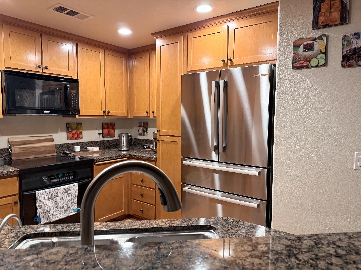 1310 Saddle Rack Street, Unit 347 San Jose, CA 95126 - Photo 11 of 42 a kitchen with stainless steel appliances granite countertop a refrigerator a stove and a sink with wooden floor