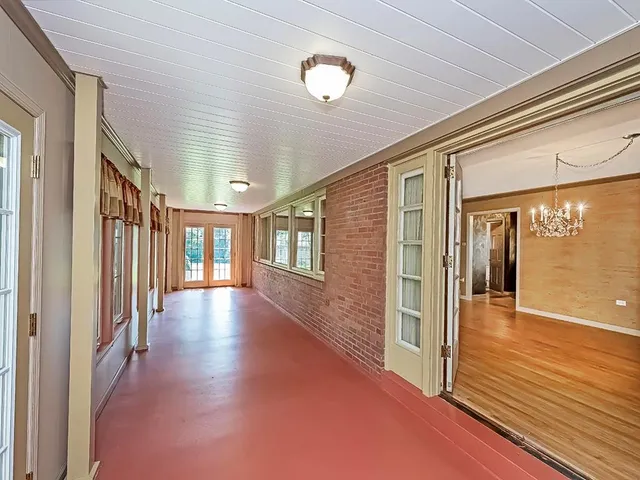 a view of a hallway with wooden floor and windows