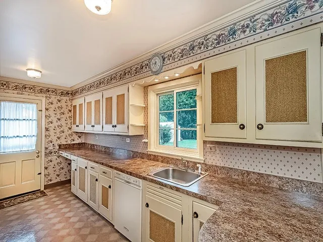 a kitchen with granite countertop a sink and a stove