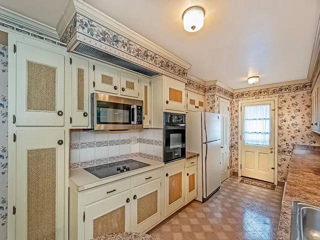 a kitchen with stainless steel appliances granite countertop a refrigerator and a stove top oven