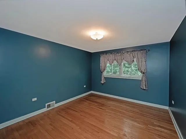a view of room with window and wooden floor