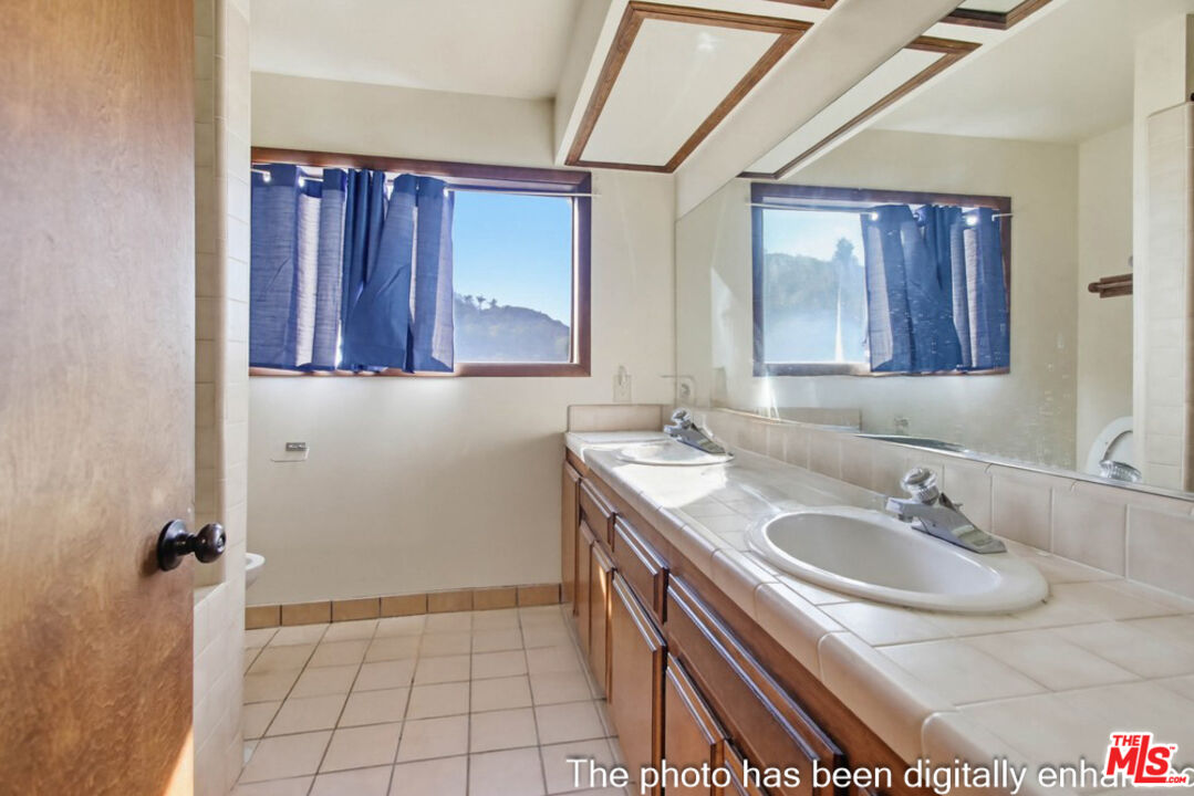 3709 Buena Creek Road Vista, CA 92084 - Photo 26 of 62 a bathroom with a sink and a mirror