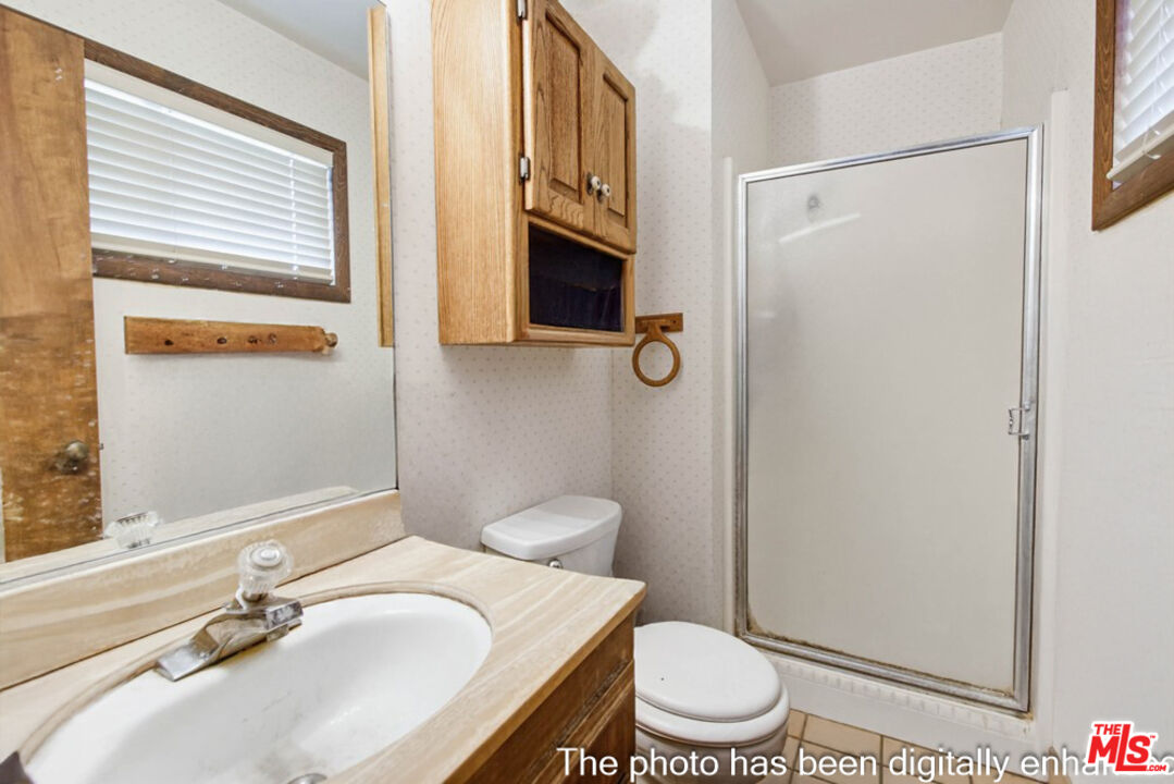 3709 Buena Creek Road Vista, CA 92084 - Photo 58 of 62 a bathroom with a granite countertop sink toilet a mirror and shower
