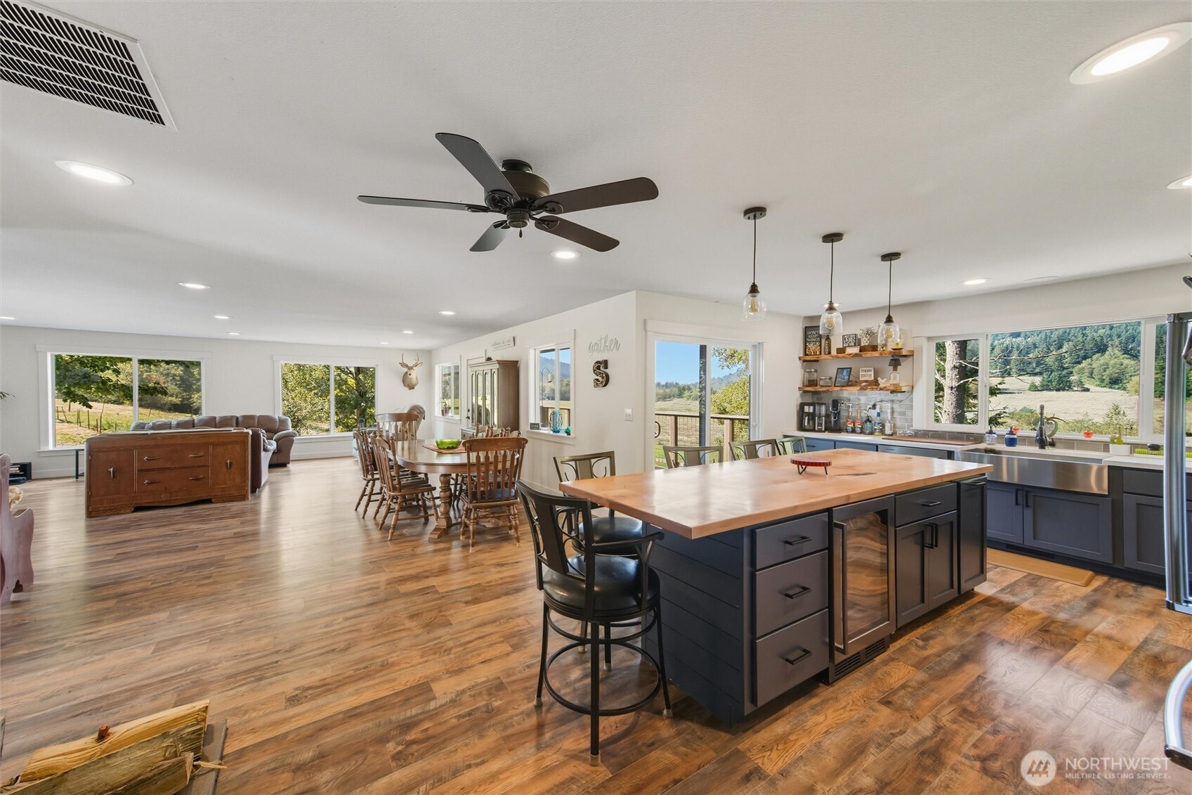 4955 South Pass Road Sumas, WA 98295 - Photo 2 of 40 a large kitchen with stainless steel appliances a stove a sink a refrigerator and a dining table with wooden floor