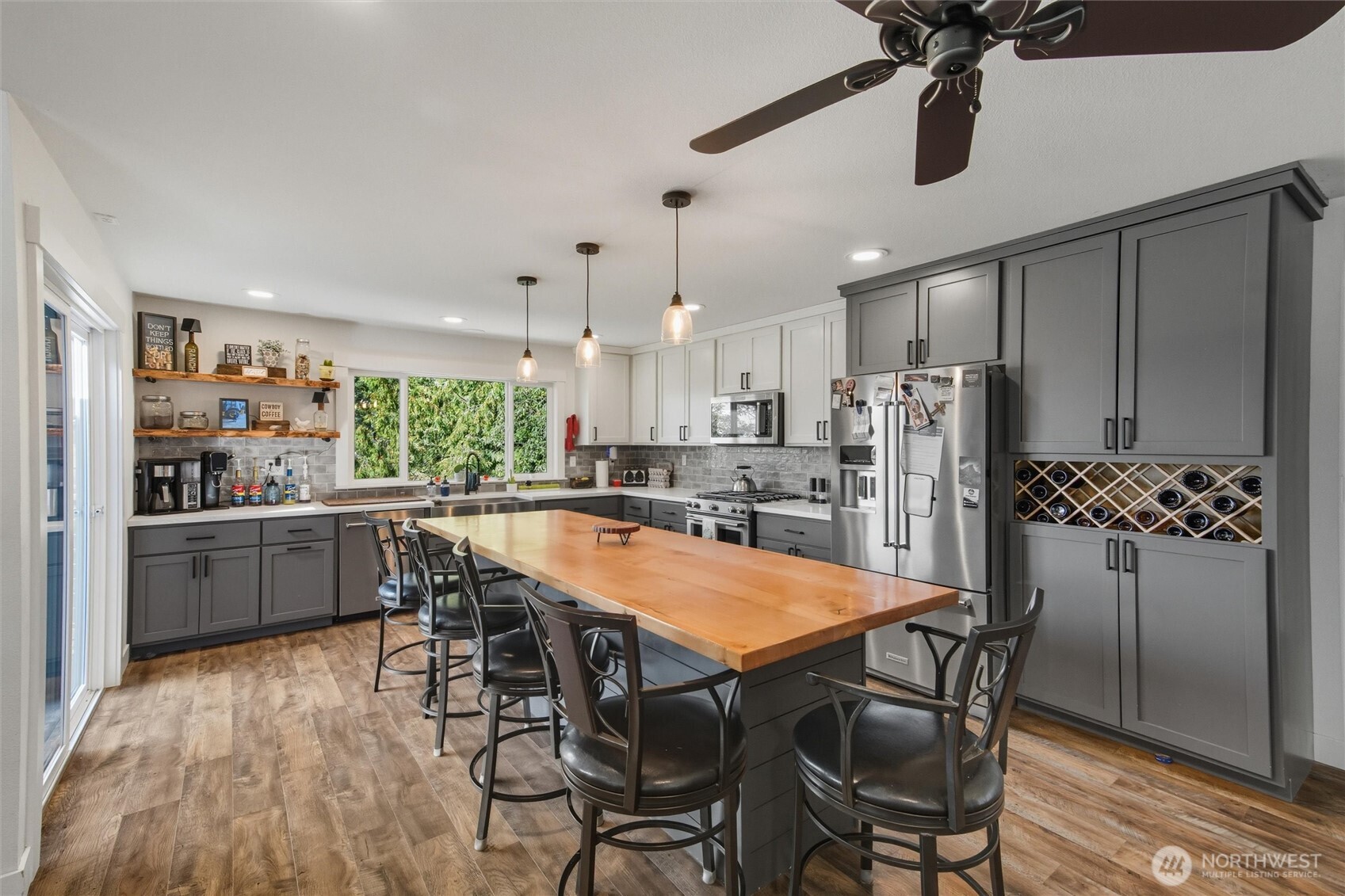 4955 South Pass Road Sumas, WA 98295 - Photo 3 of 40 a kitchen with stainless steel appliances kitchen island granite countertop a dining table chairs and white cabinets