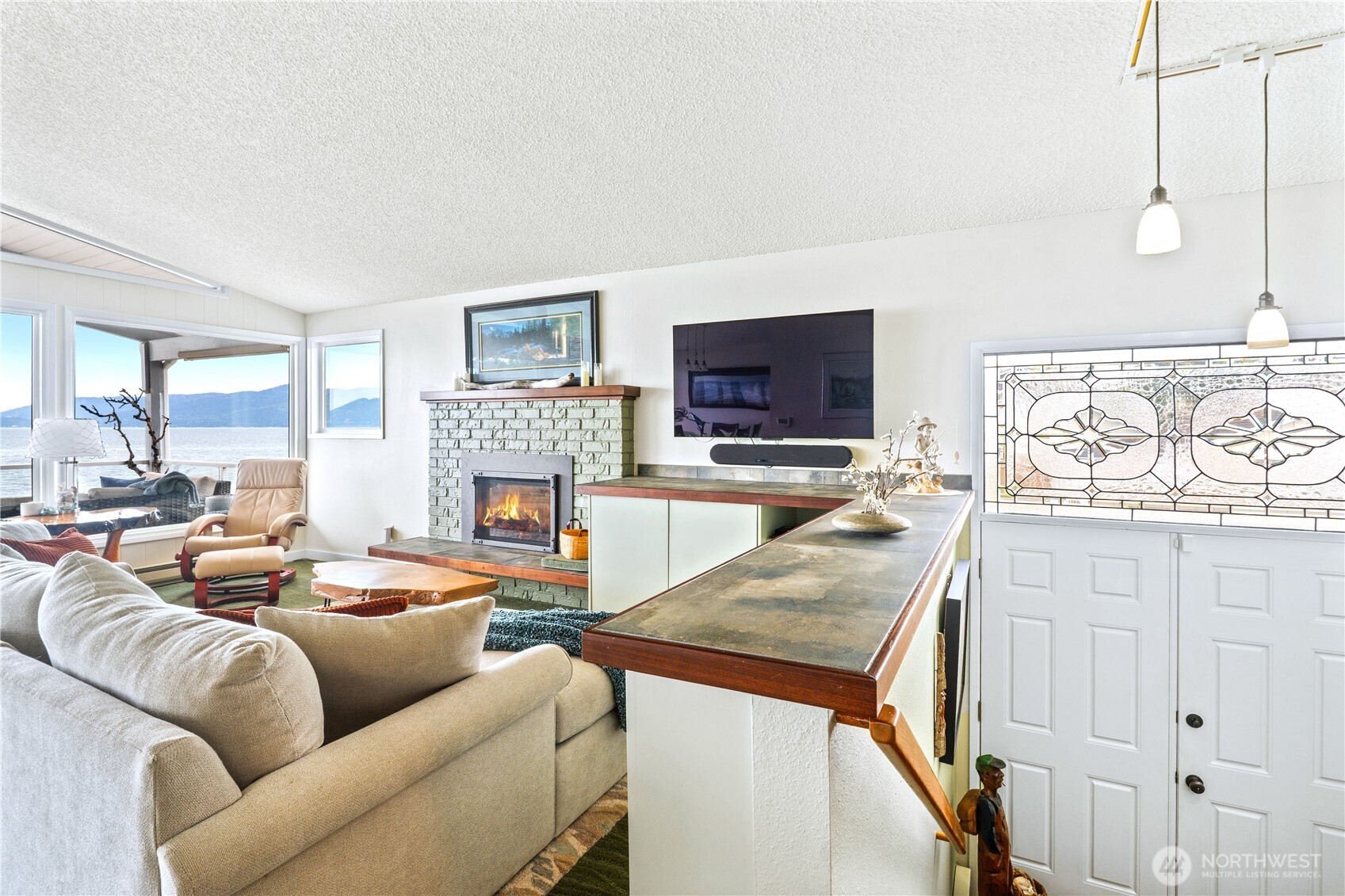 9609 Samish Island Road Bow, WA 98232 - Photo 6 of 33 a living room with furniture a flat screen tv and a fireplace