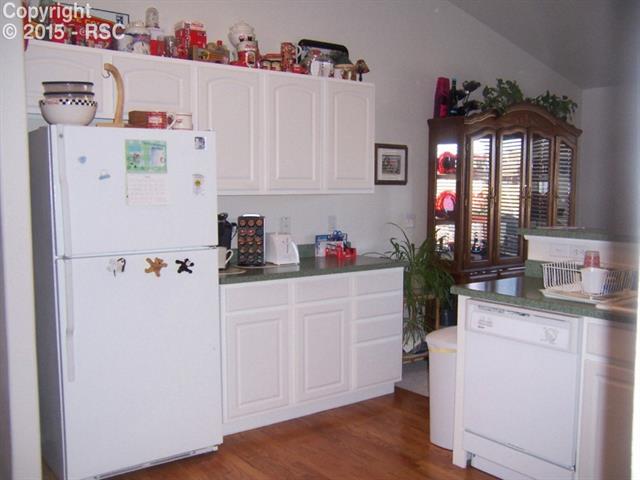 12456 Snaffle Bit Road Peyton, CO 80831 - Photo 5 of 14 Kitchen with super clean white cabinets and white appliances.