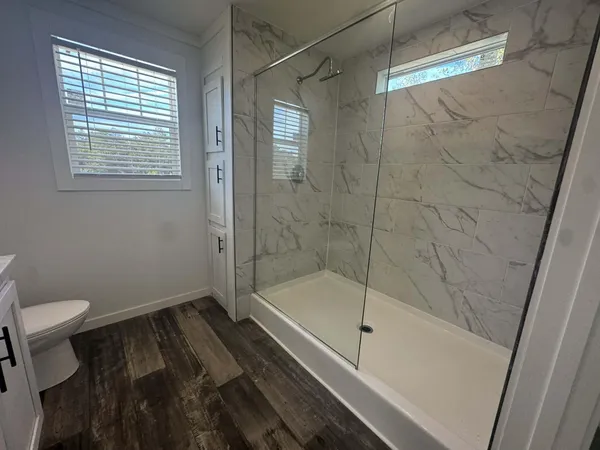 a bathroom with a granite countertop sink toilet and shower