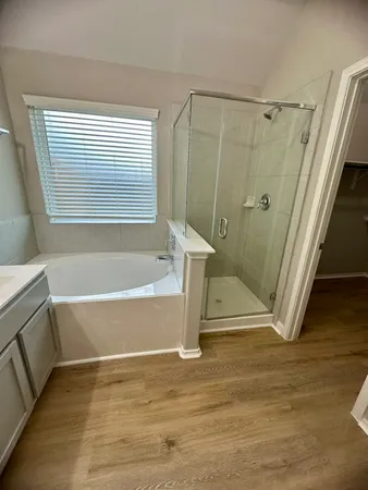 a bathroom with a tub a sink and a window