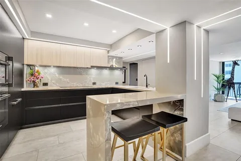 a kitchen with stainless steel appliances a dining table and chairs