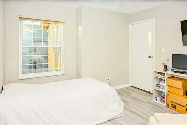 a bedroom with a bed and a flat tv screen on the dresser