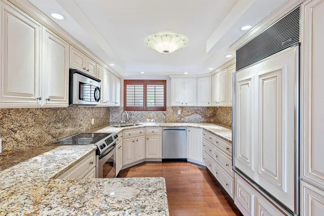 a kitchen with granite countertop a sink and cabinets