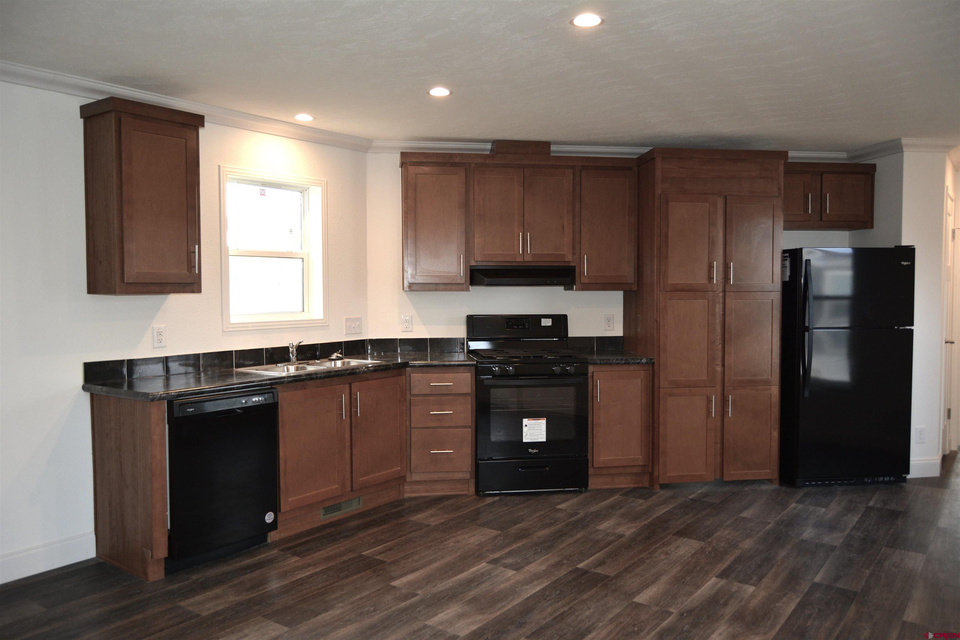 62650 Lasalle Road, Unit 811 Montrose, CO 81403 - Photo 3 of 12 a kitchen with a refrigerator and a stove top oven