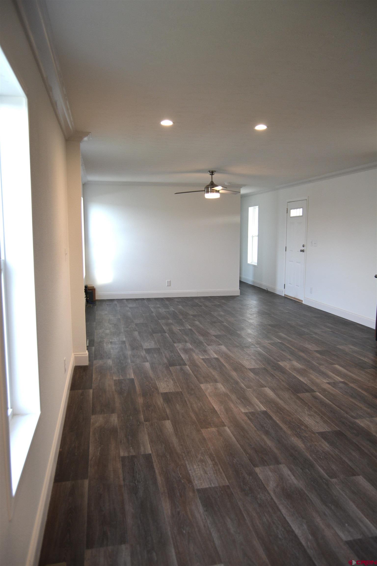 62650 Lasalle Road, Unit 811 Montrose, CO 81403 - Photo 5 of 12 an empty room with wooden floor and windows