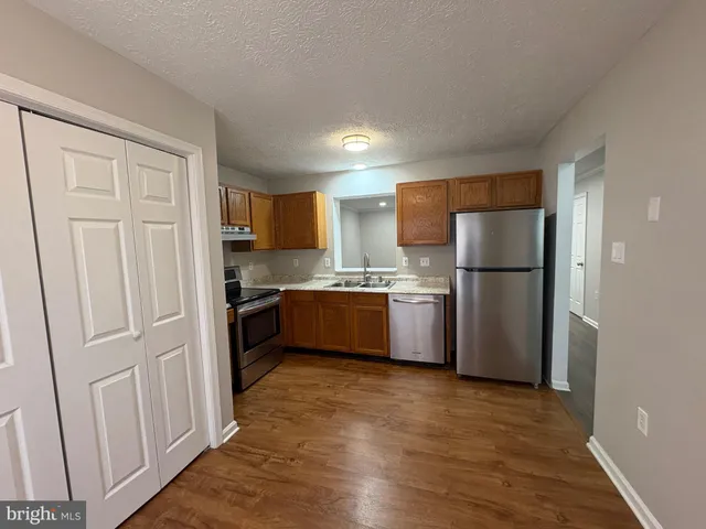 a kitchen with a refrigerator a sink and a cabinets