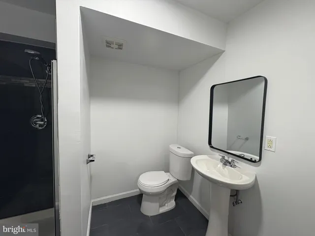 a bathroom with a toilet sink and mirror