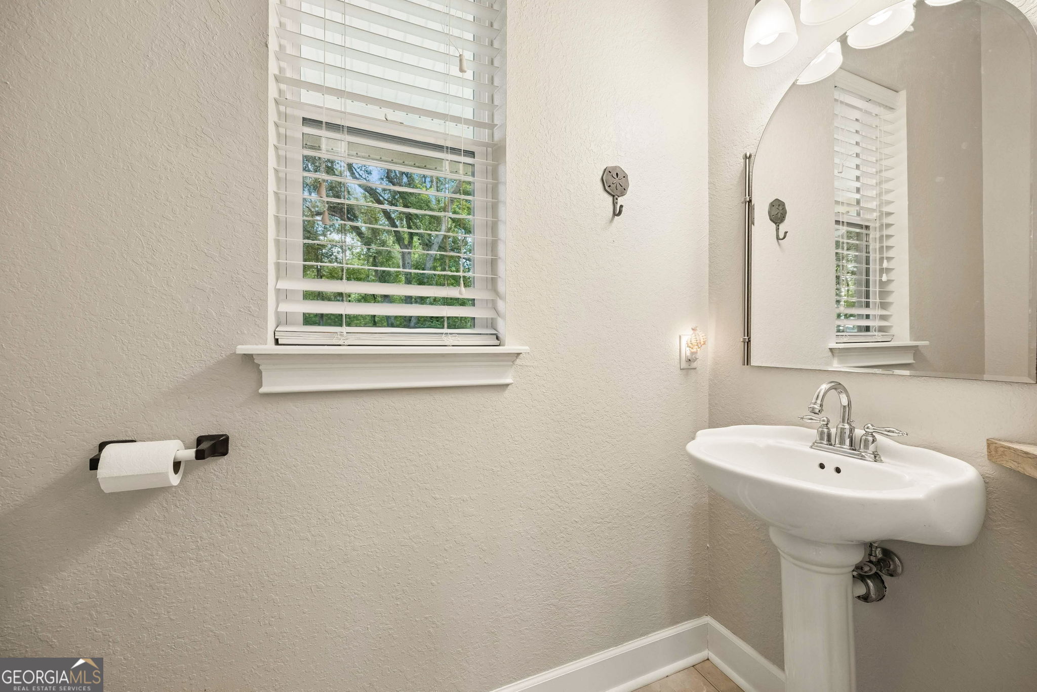 706 Hopewell Point Road White Oak, GA 31568 - Photo 27 of 84 Convenient half bath featuring pedestal sink, window for natural light, and tasteful finishes.