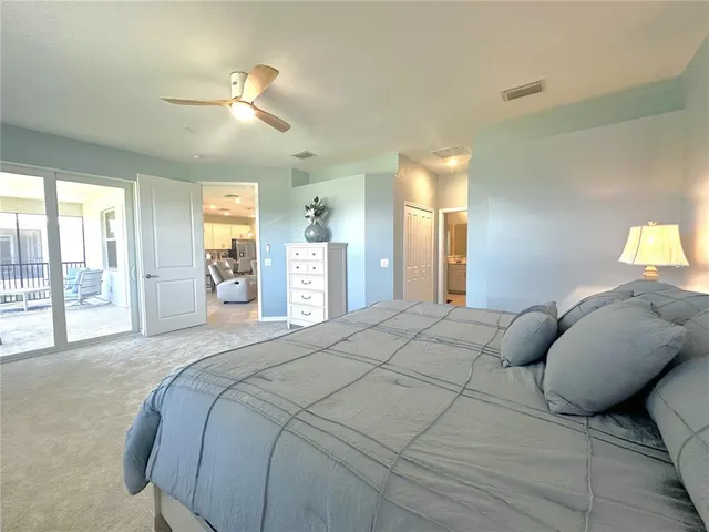 a spacious bedroom with a bed and glass walk in closet