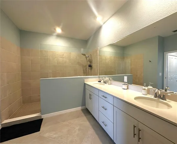 a bathroom with a double vanity sink mirror and shower