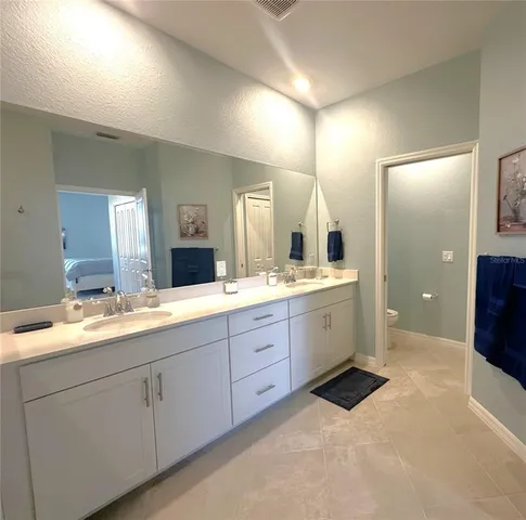 a spacious bathroom with a double vanity sink and mirror