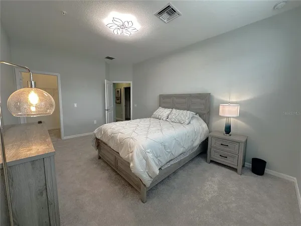 a bedroom with a bed and a lamp