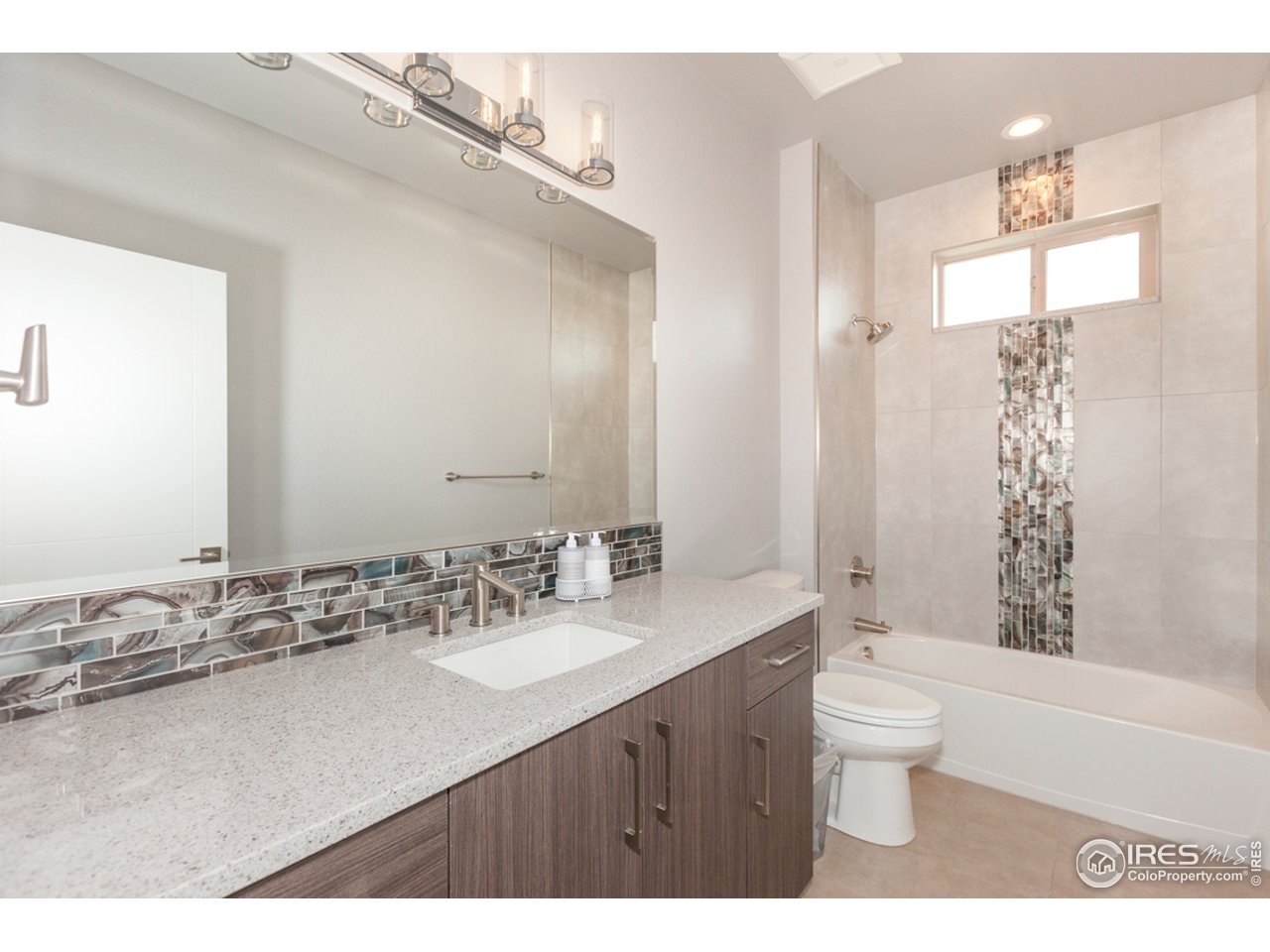 3818 Bridle Ridge Circle Fort Collins, CO 80524 - Photo 26 of 40 a bathroom with a granite countertop sink a toilet a mirror and bathtub