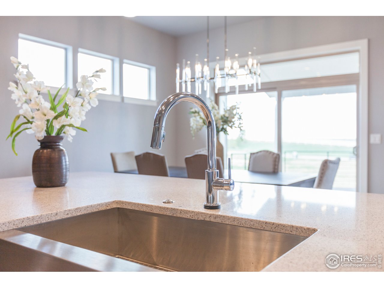 3818 Bridle Ridge Circle Fort Collins, CO 80524 - Photo 8 of 40 a kitchen with a sink a faucet a potted plant and a large window