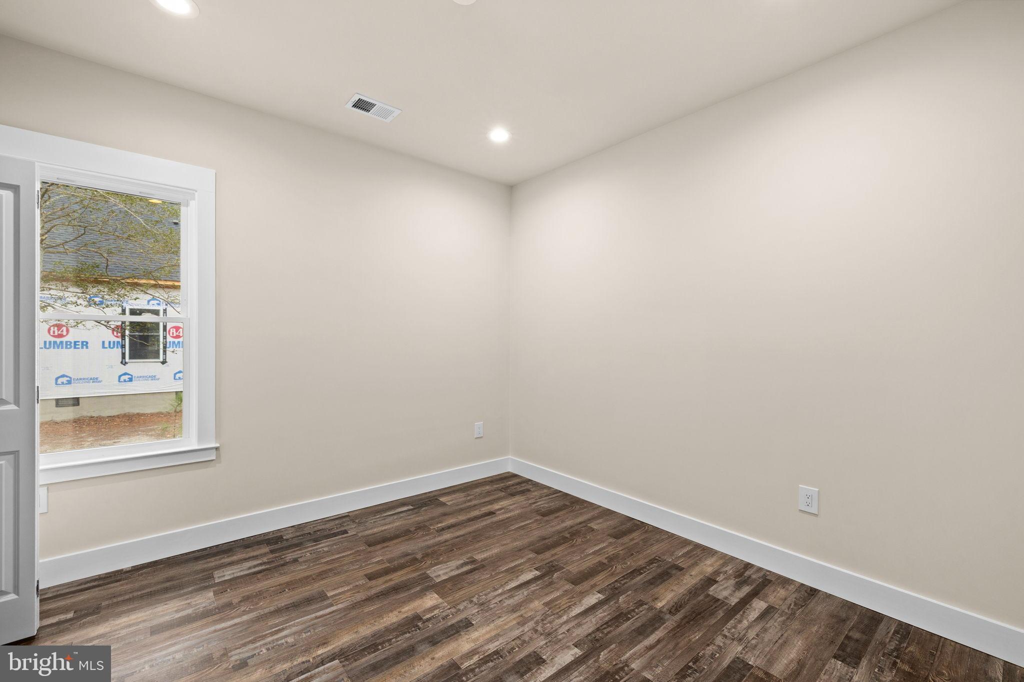 316 9th Street Colonial Beach, VA 22443 - Photo 12 of 59 a view of an empty room with wooden floor and a window