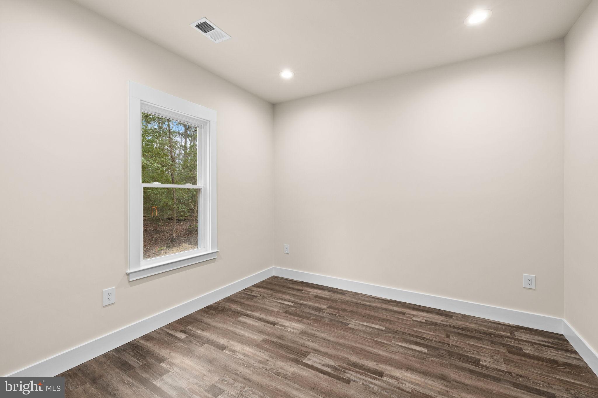 316 9th Street Colonial Beach, VA 22443 - Photo 13 of 59 an empty room with wooden floor and windows