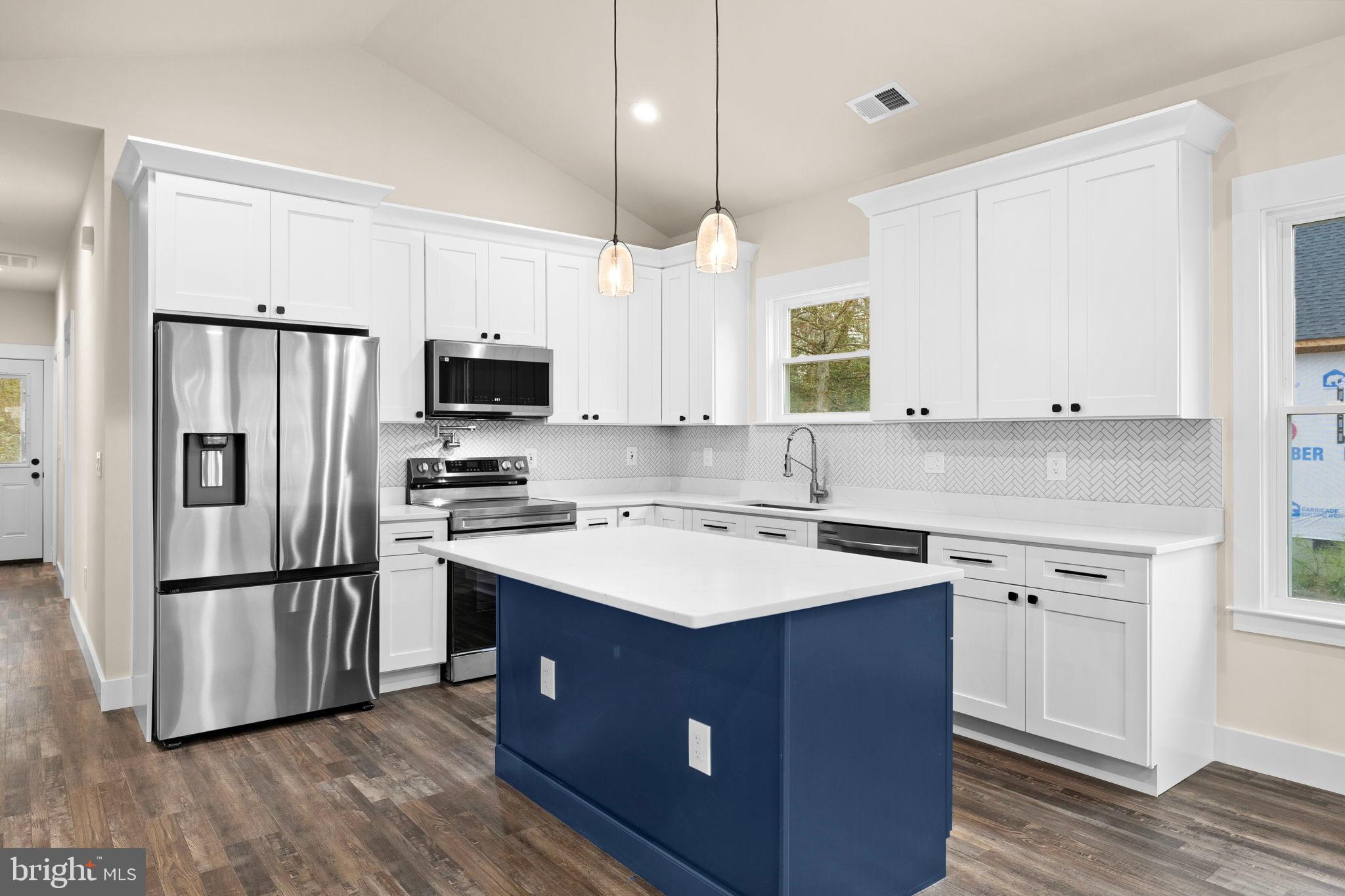 316 9th Street Colonial Beach, VA 22443 - Photo 7 of 59 a kitchen with a sink a center island wooden floor and stainless steel appliances