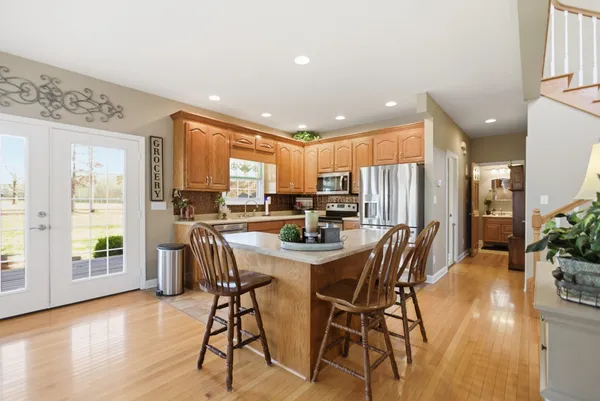a view of a livingroom with furniture staircase and a kitchen view