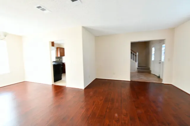 a view of an empty room with wooden floor