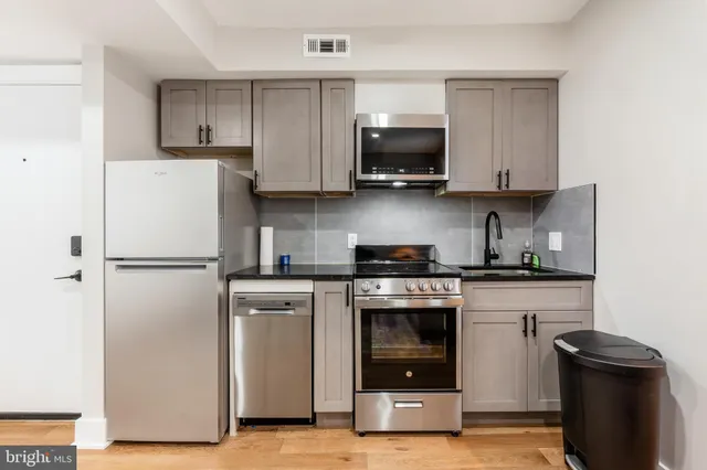 a kitchen with white cabinets and stainless steel appliances