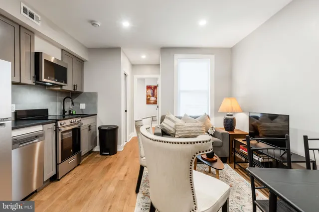 a kitchen with stainless steel appliances kitchen island granite countertop a sink dishwasher stove and microwave with wooden floor