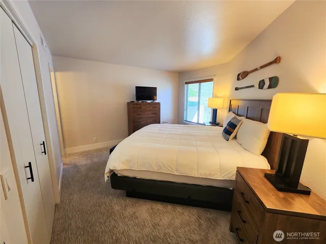 a spacious bedroom with a bed and wooden floor