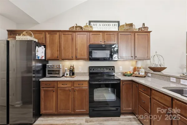 a kitchen with stainless steel appliances granite countertop a stove a sink and a refrigerator
