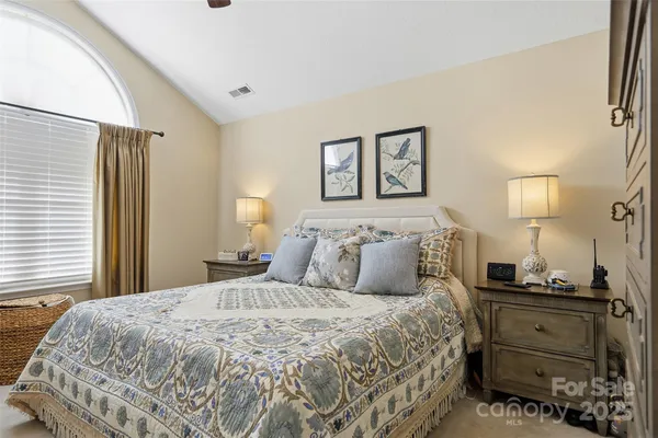 a bedroom with a bed and a chandelier
