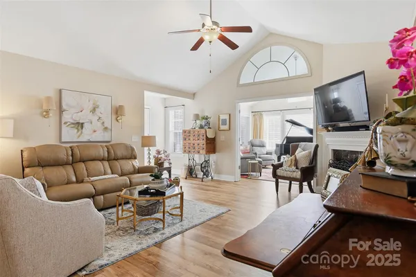 a living room with furniture a flat screen tv and a chandelier