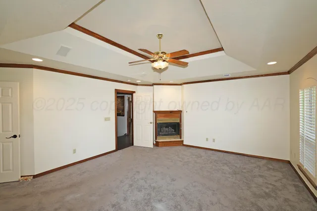 an empty room with windows and ceiling fan
