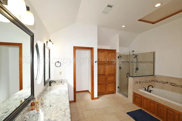 a spacious bathroom with a tub sink and mirror