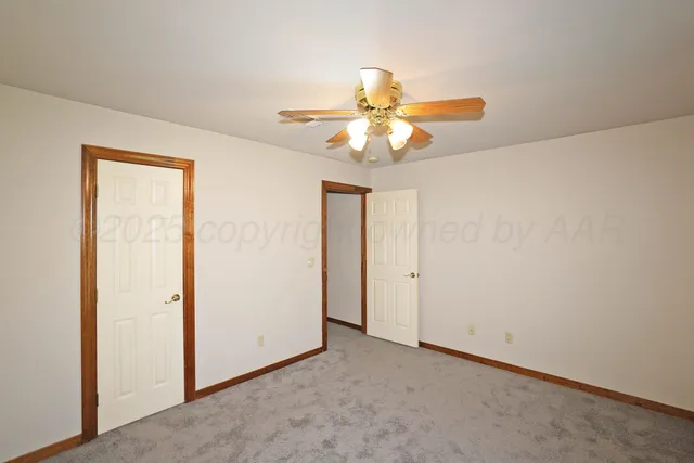 an empty room with a chandelier fan